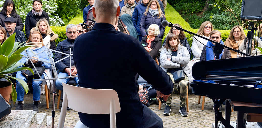 Público frente a un músico durante un concierto en el jardín del Museo Larreta
